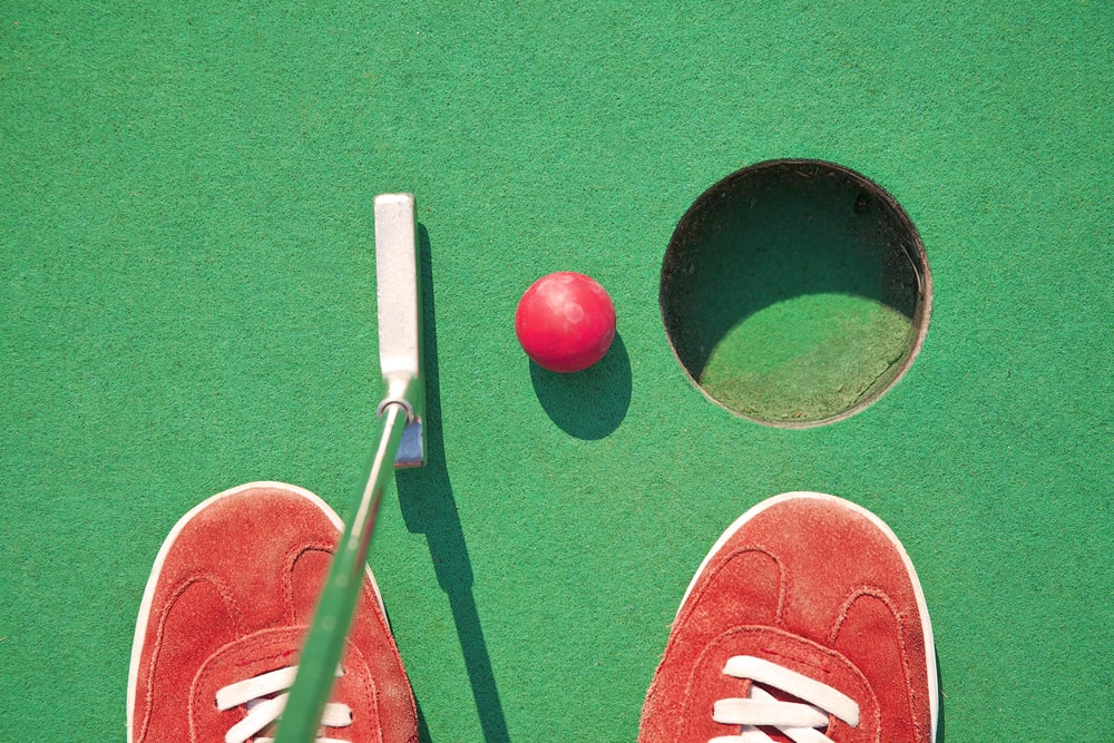 Image of a red shoe of a person at the mini golf